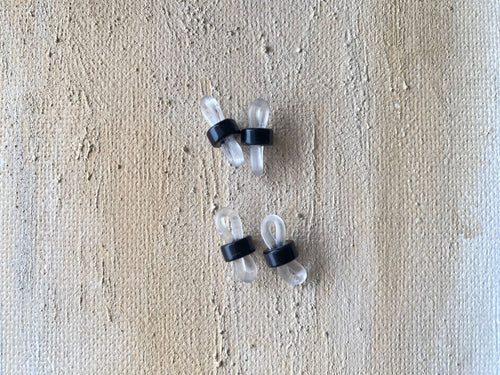 May include: Four clear plastic eyeglass holders with black rubber bands. The holders are designed to keep glasses from sliding down or dropping.